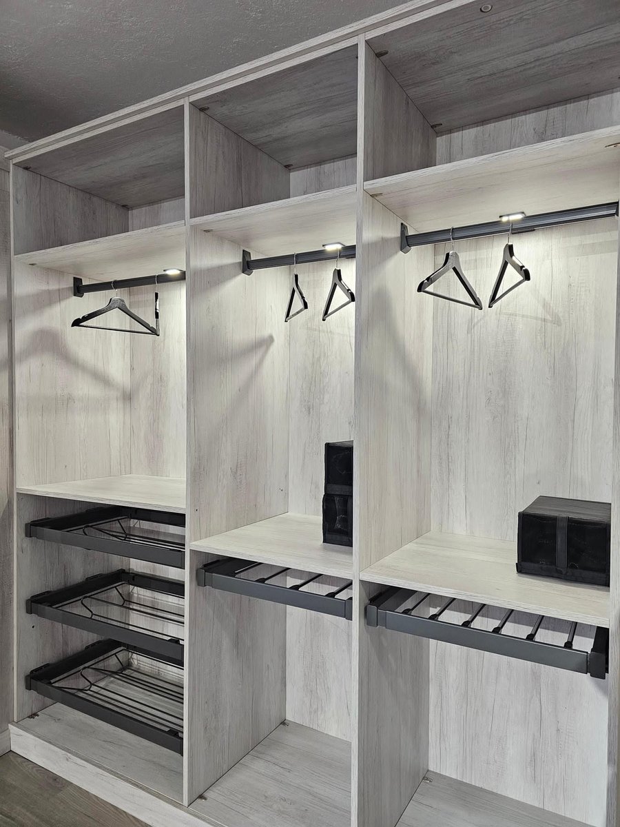 Interior de armario con perchero y zapatero metálico
